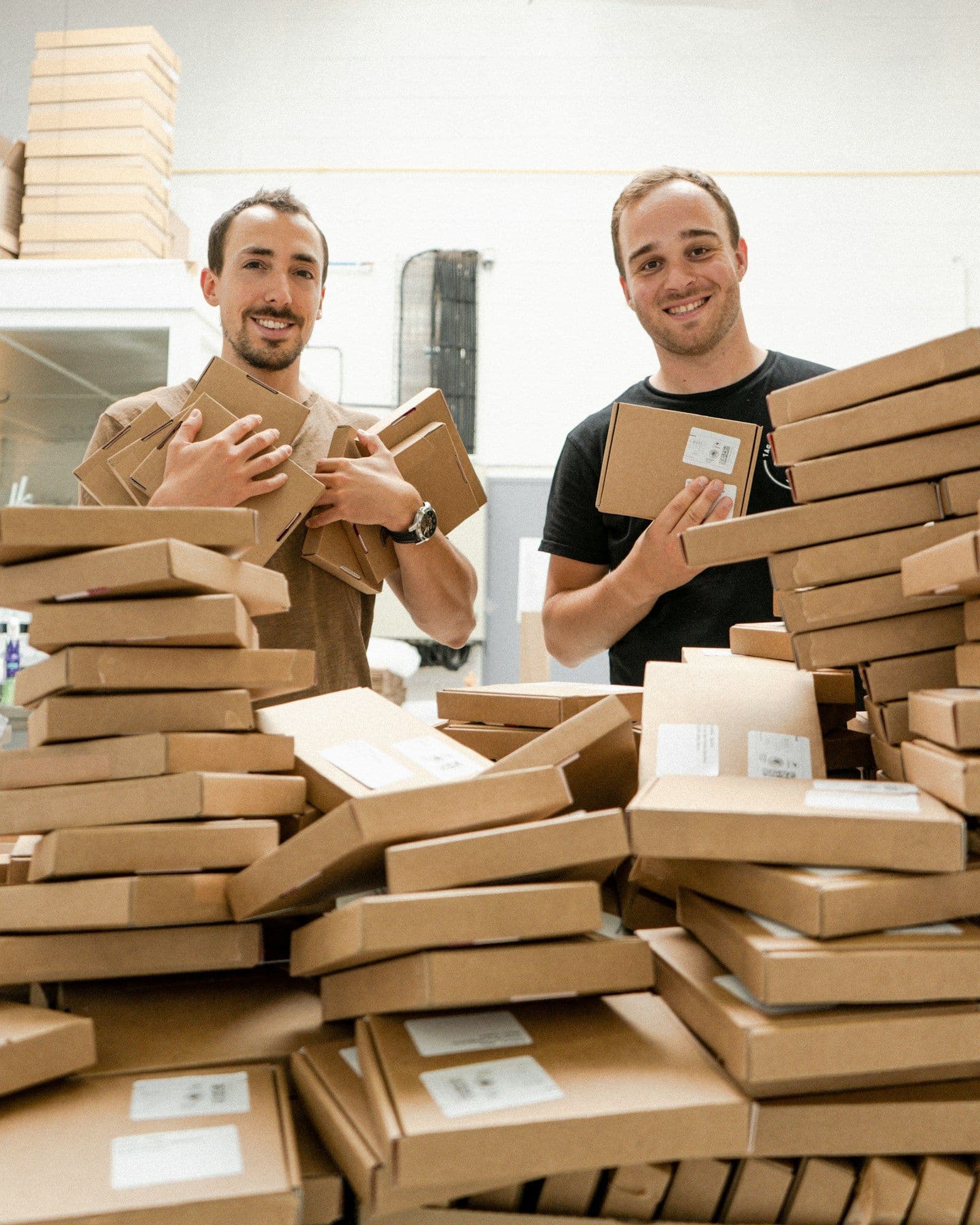 Twee mensen tussen stapels verzenddozen