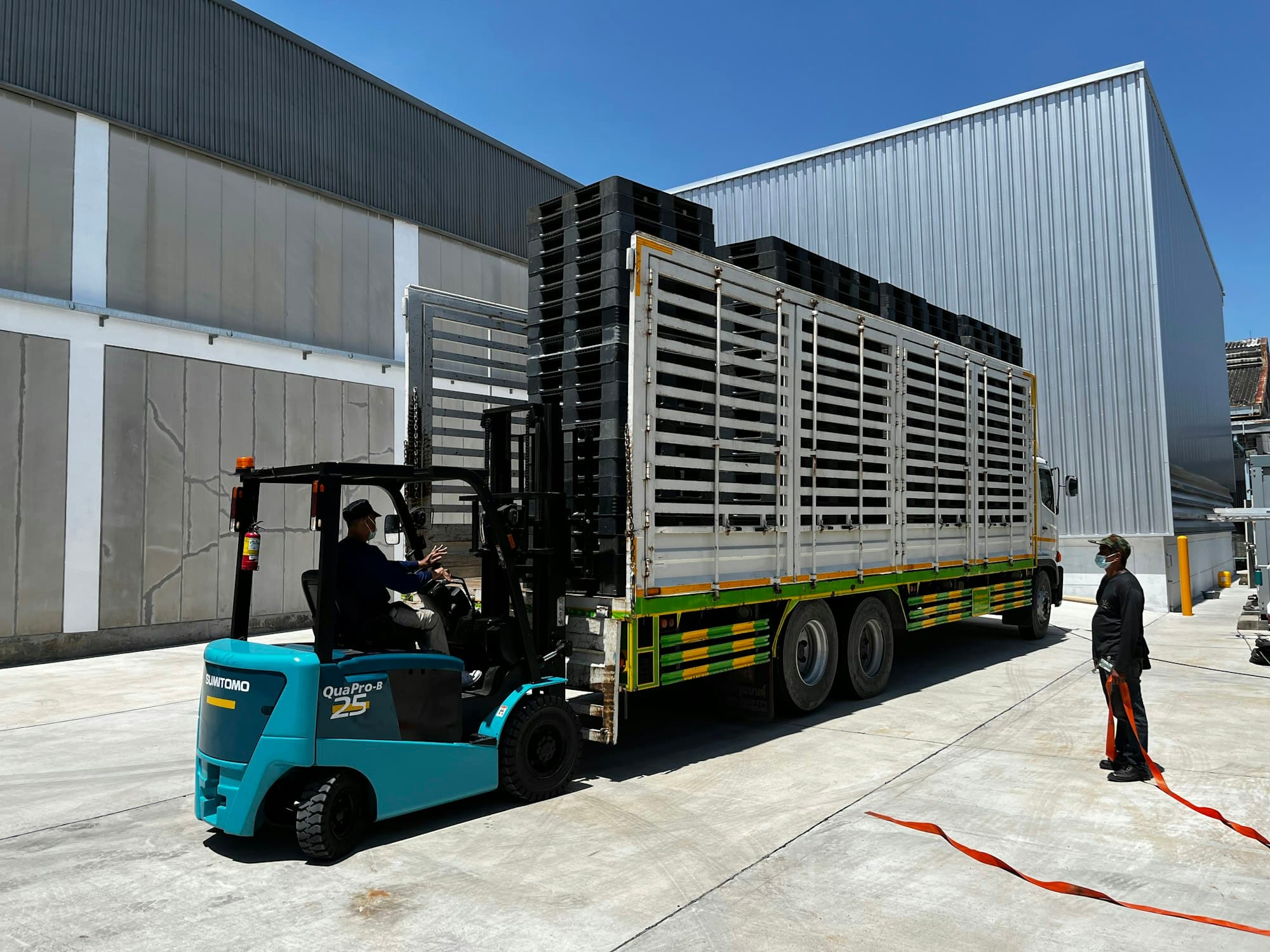 Heftruck laadt pallets in een vrachtwagen aan een magazijn