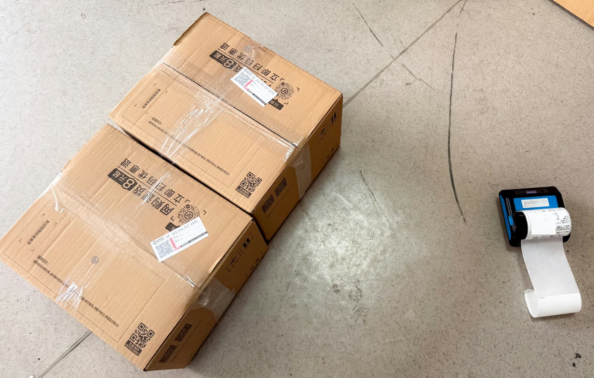 Ingevoerde kartonnen dozen met etiketten naast een draagbare etiketprinter