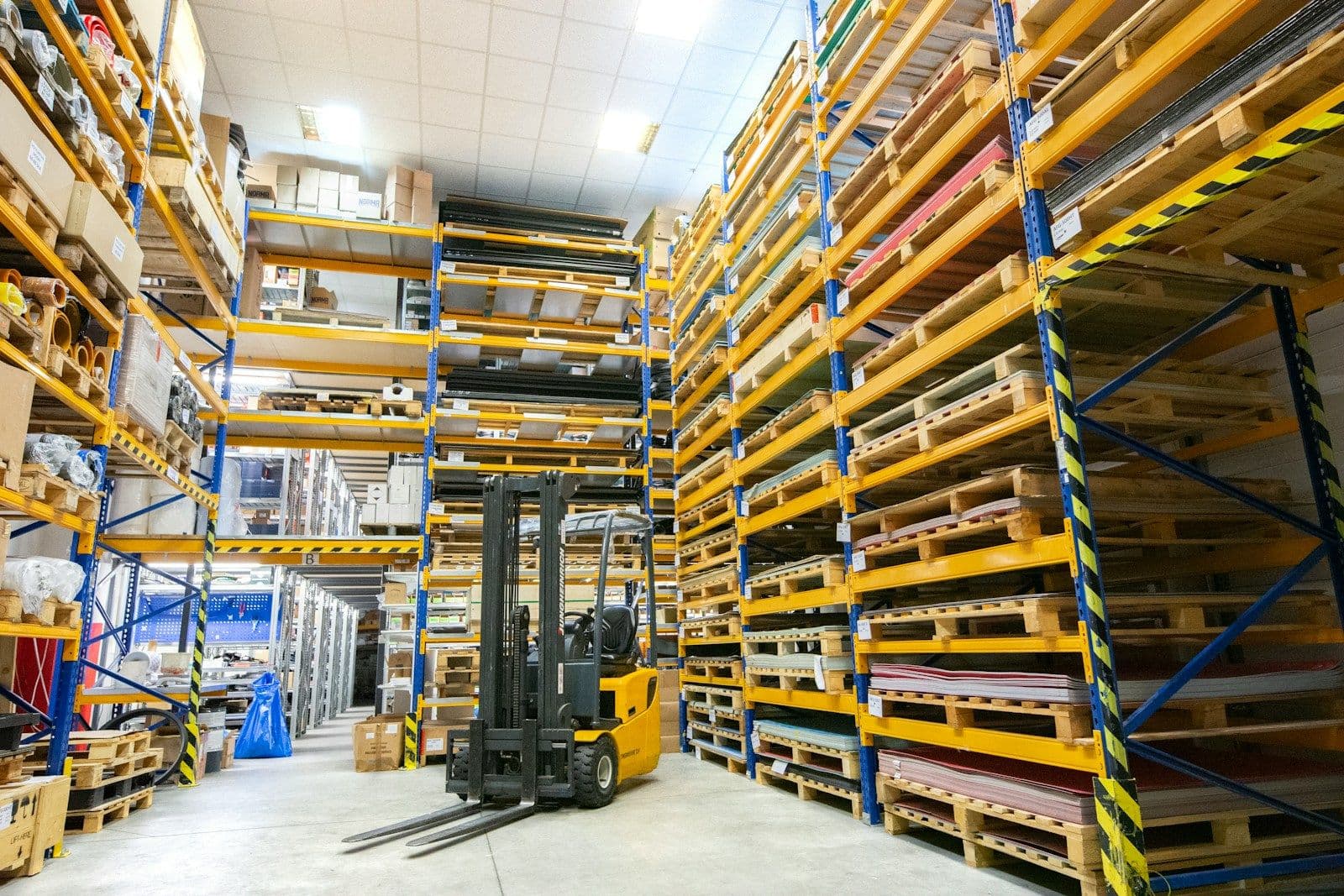 Magazijn met hoge palletrekken en een heftruck
